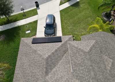 Aerial shot of a compact solar panel system installed on the front-facing roof of a house, optimized for energy efficiency.