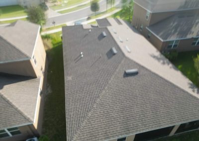 Aerial view of a residential roof in a suburban neighborhood, ideal for evaluating solar panel setup potential.