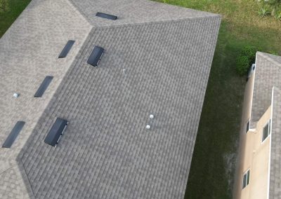 Aerial view of a residential roof showcasing multiple ventilation systems and ample space for solar panel placement.